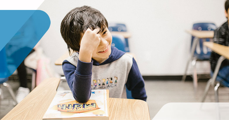 boy at desk in classroom