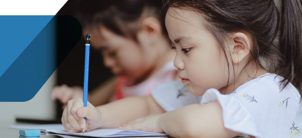 Student writing at their desk